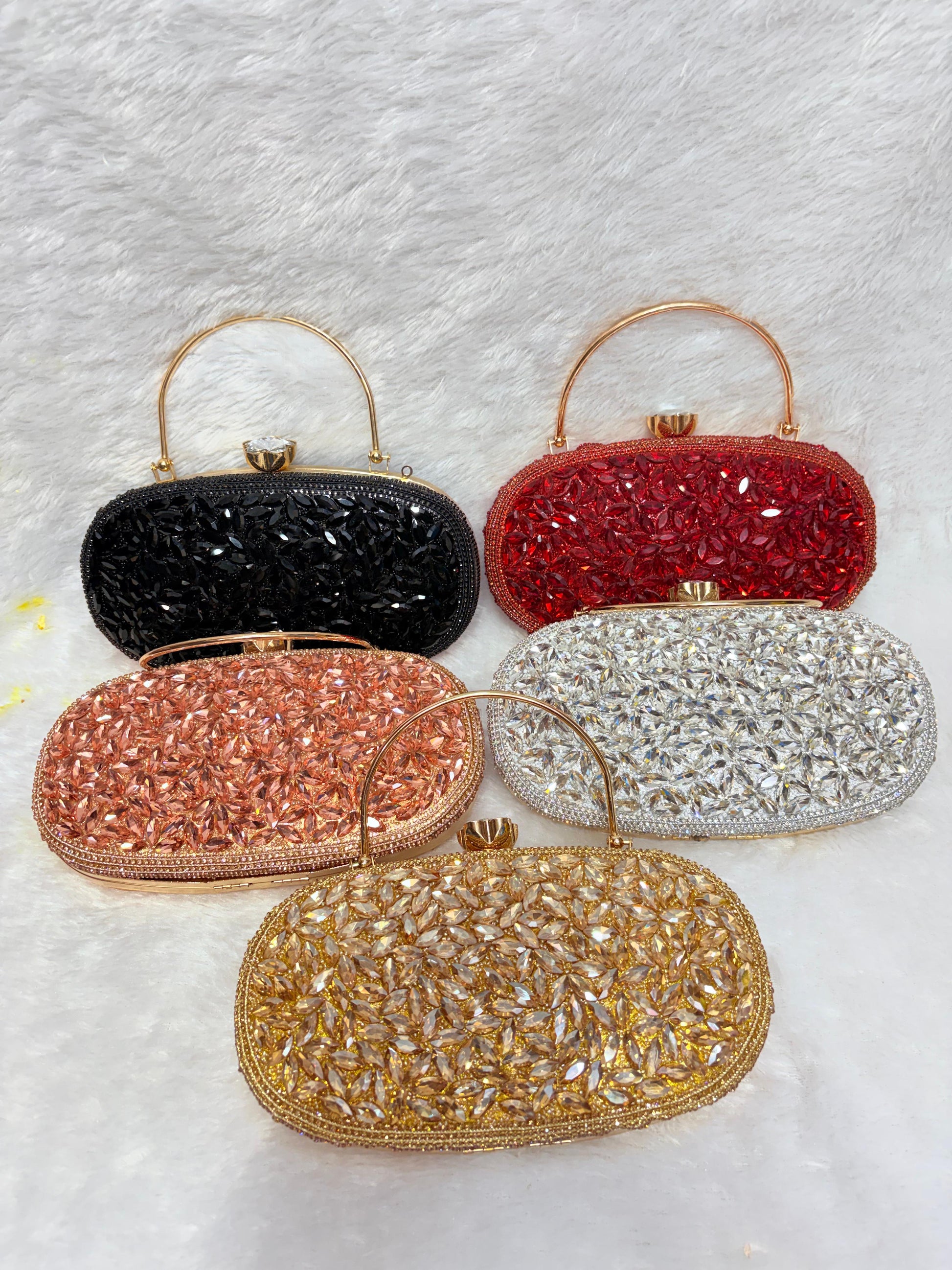 Set of five beaded handbags in black, red, rose gold, silver, and gold on a textured white background.